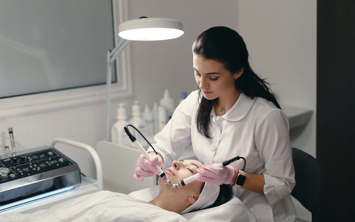 Cosmetologist giving a client a machine facial treatment